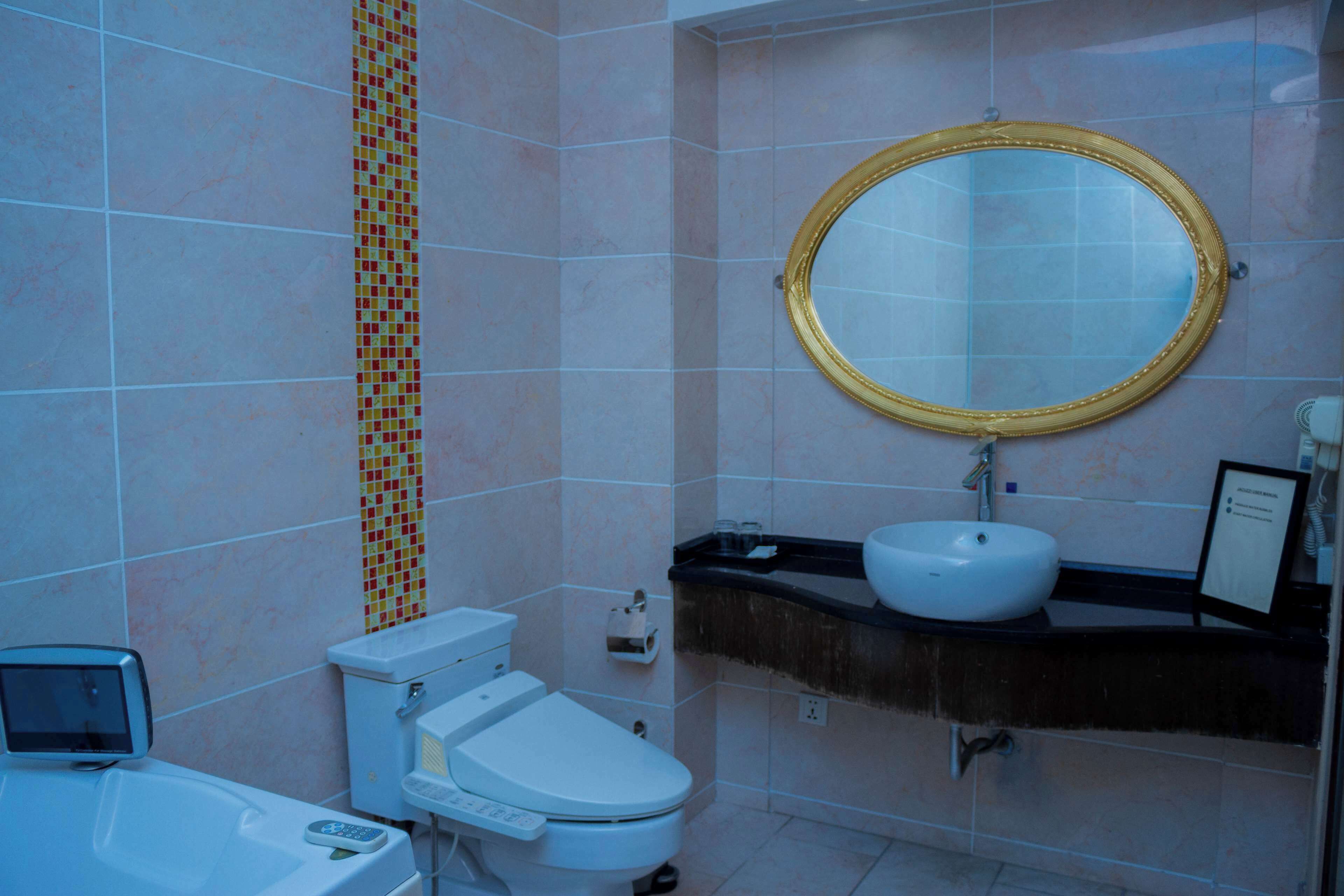Une salle de bain avec des toilettes, un lavabo et un miroir.