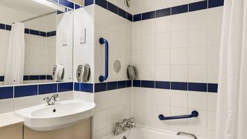 A bathroom with a white sink, a mirror, a shower with a handheld showerhead, and a bathtub with a grab bar.