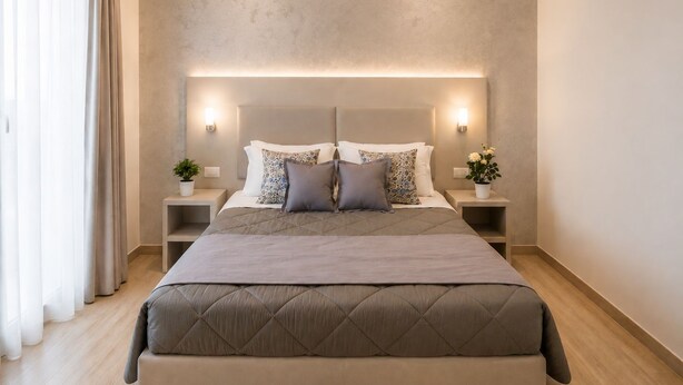 A modern bedroom with a large bed, bedside tables, and a neutral color scheme.