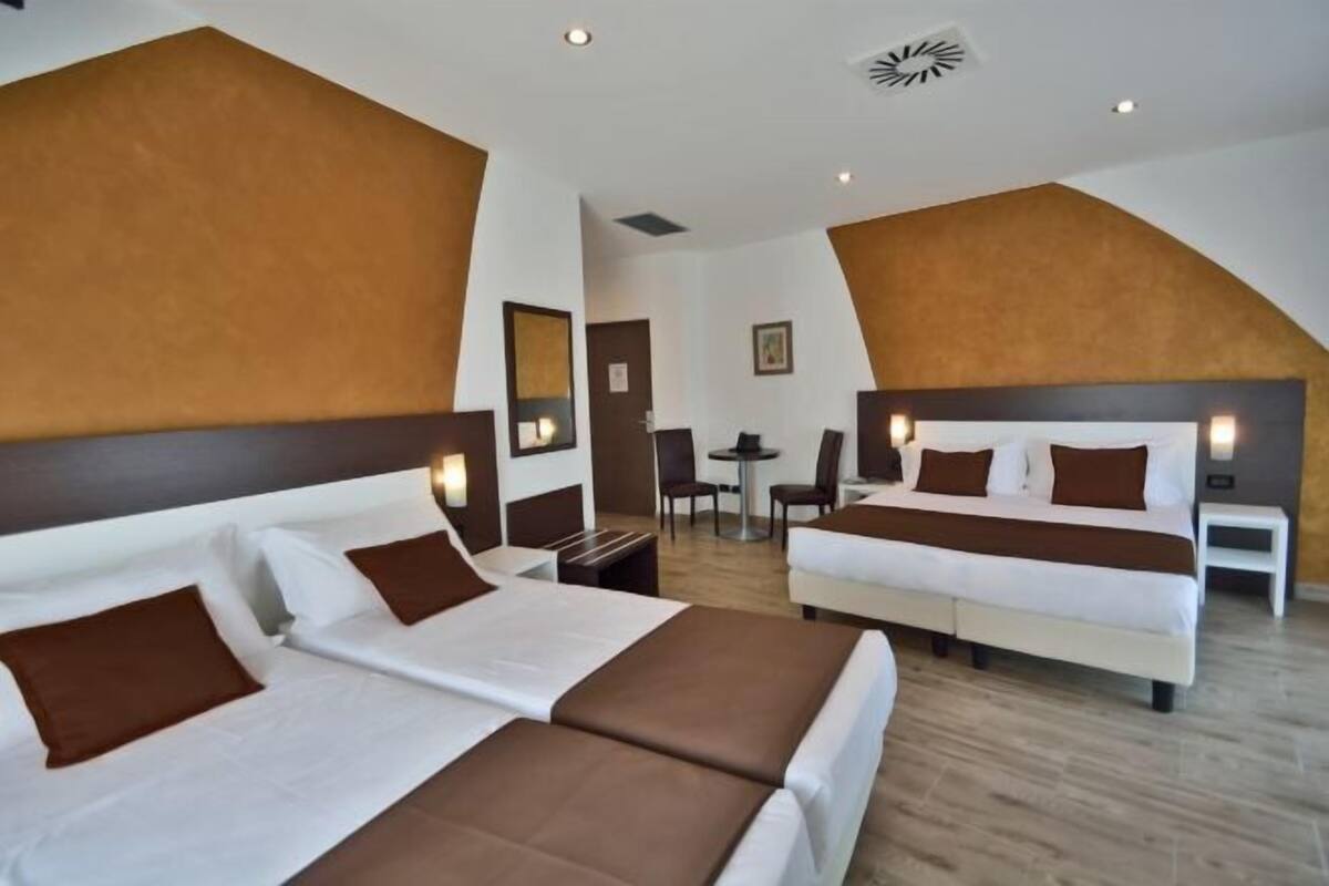 Een hotelkamer met twee bedden, een bureau en een stoel.