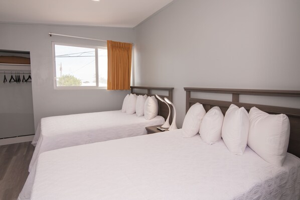A hotel room with two single beds, a window with curtains, a wardrobe, and a hanging coat rack. - The Palms On Ocean (Pompano Beach)