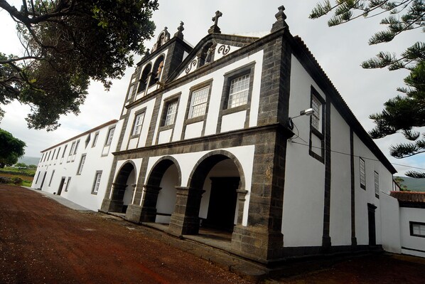 Stunning historic building with a central entrance and symmetrical facade, set amidst a serene natural backdrop.