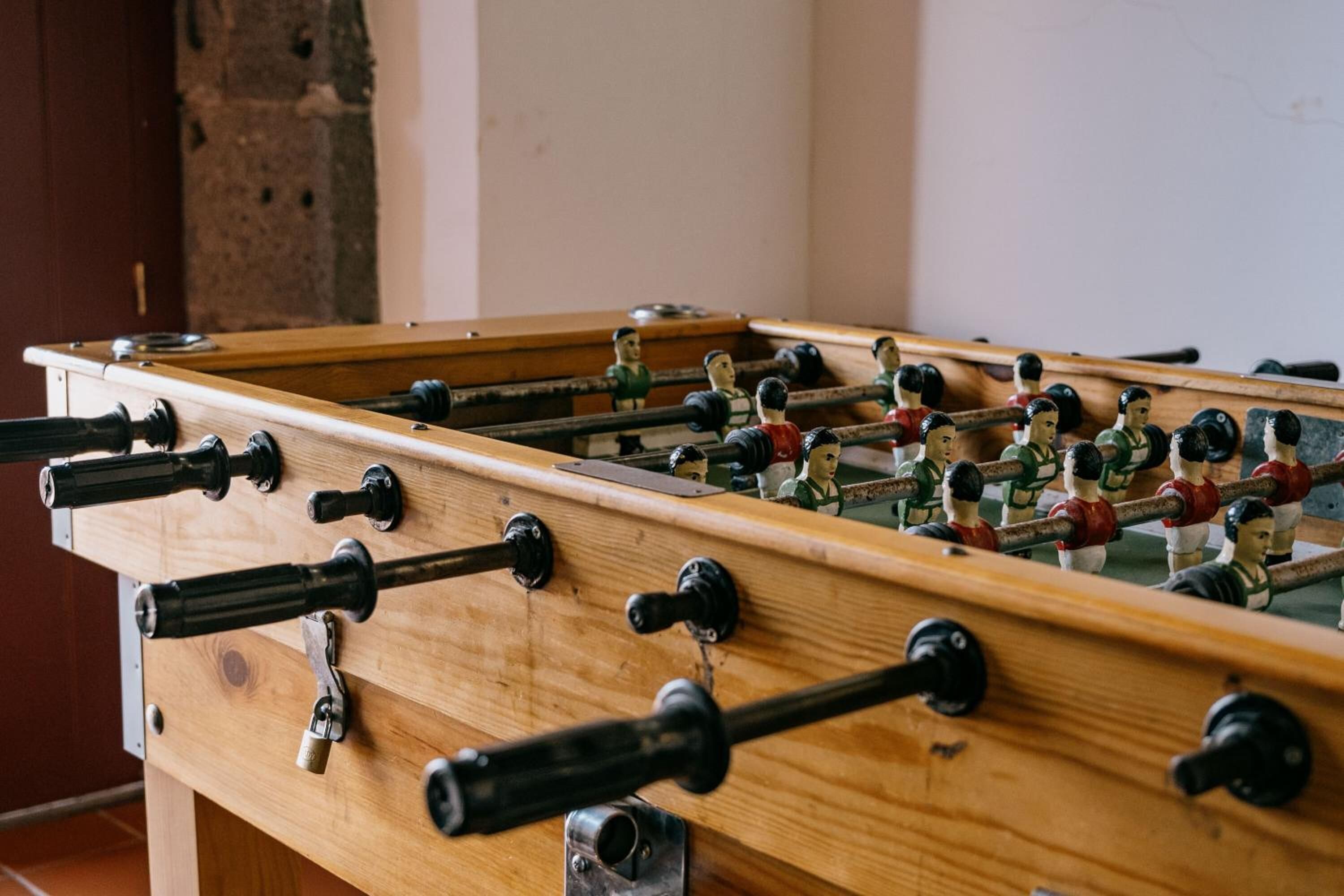 A wooden foosball table with multiple rods and figures.