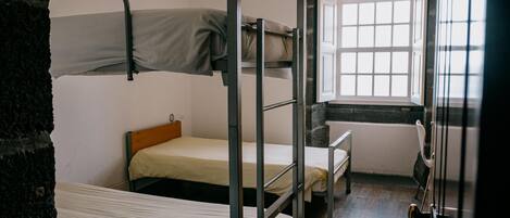 A bunk bed room with a window and a door.
