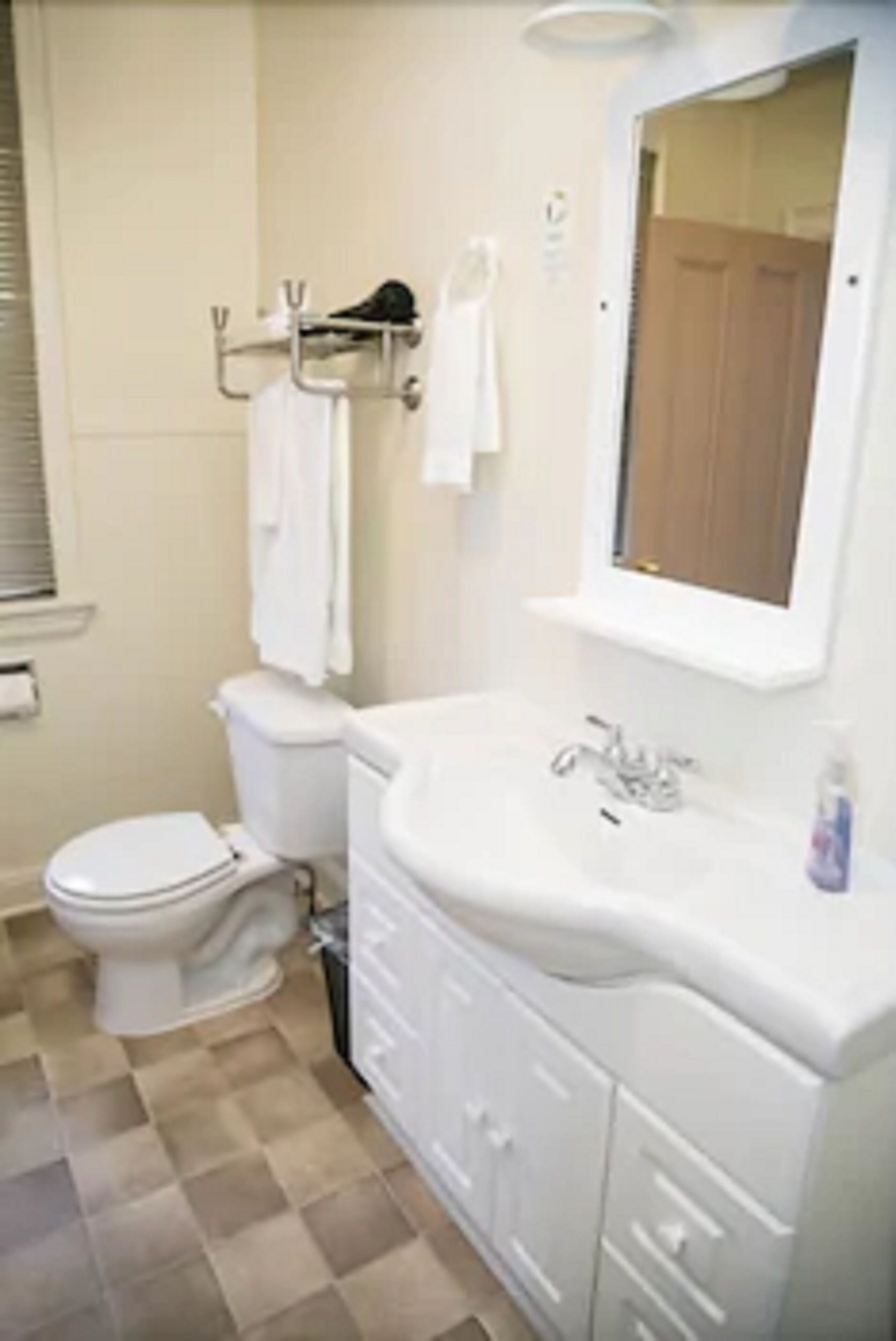 Un baño con inodoro, lavamanos y espejo.