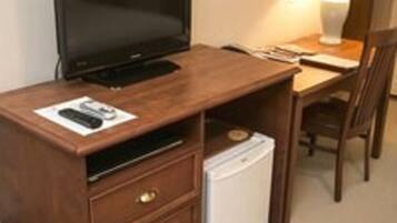 Ein Holztisch mit Fernseher, Lampe und Kühlschrank.