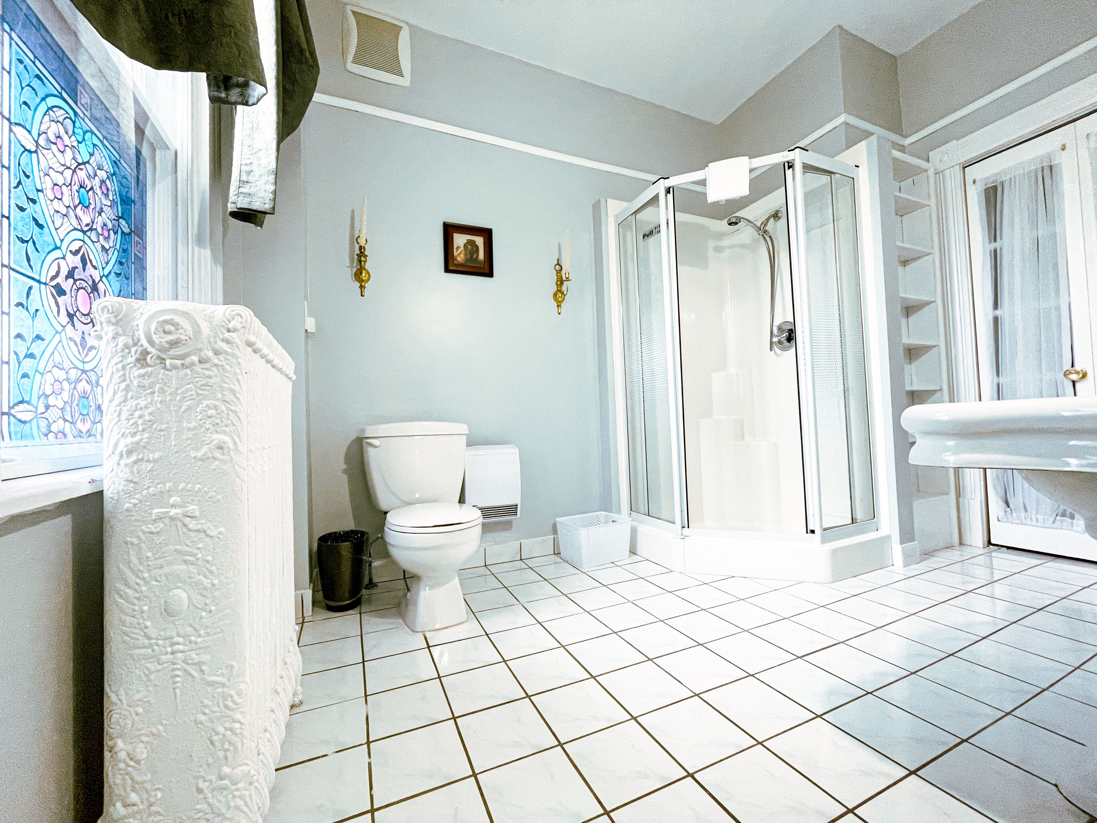Un baño con inodoro blanco, ducha con cerramiento de vidrio y lavamanos blanco.