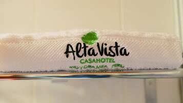 A white towel with the text "AltaVista CASAHOTEL MOYOBAMBA PERU" and a green leaf logo.