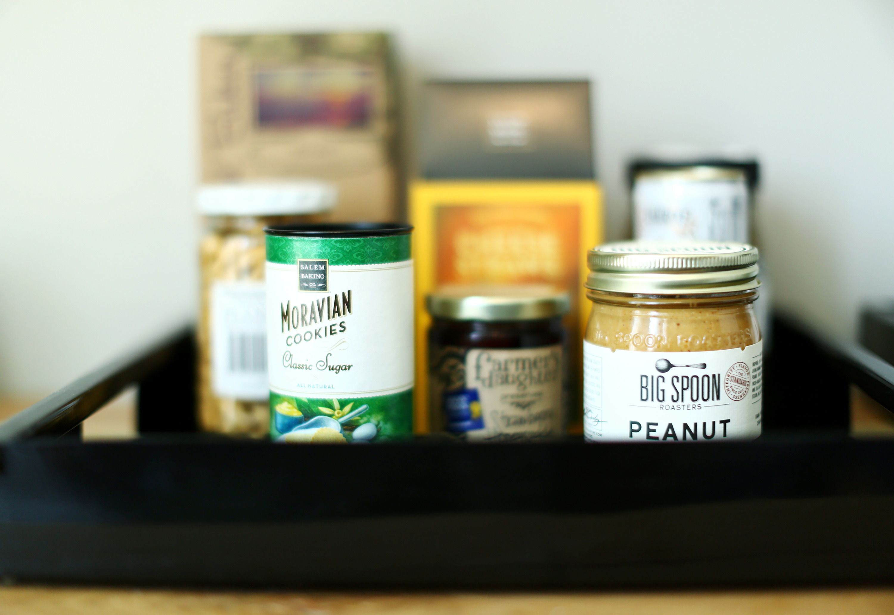A tray with jars of cookies and peanut butter.