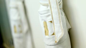 A close-up of a white garment with gold trim and a pocket.