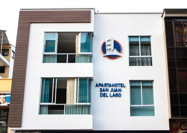 Ein modernes Gebäude mit einem Schild für "APARTAHOTEL SAN JUAN DEL LAGO".