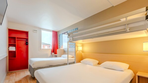 Habitación de hotel con dos camas, un armario rojo, un ventanal con vistas y una litera.