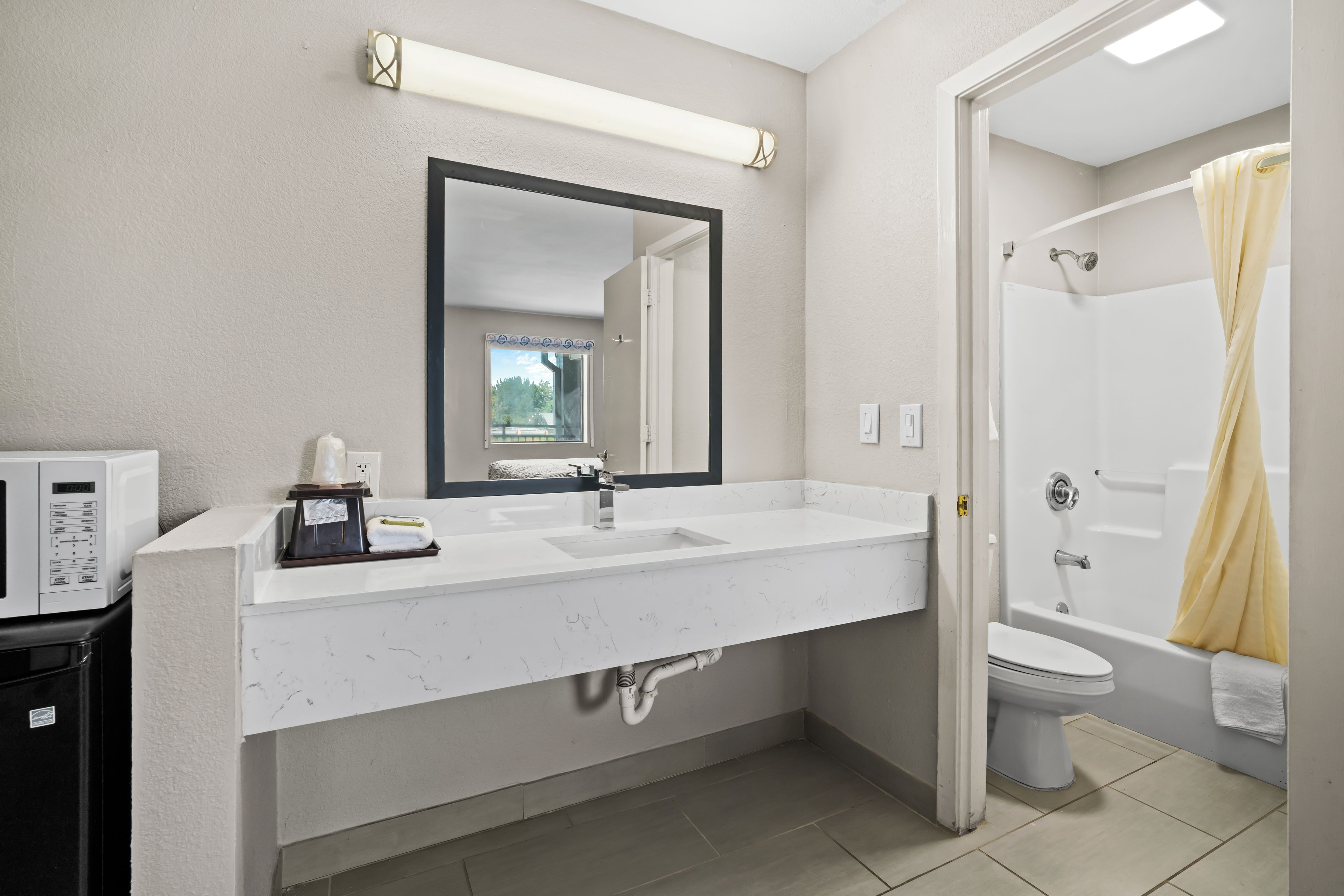 Un baño con un lavamanos blanco, un espejo, un inodoro y una ducha.