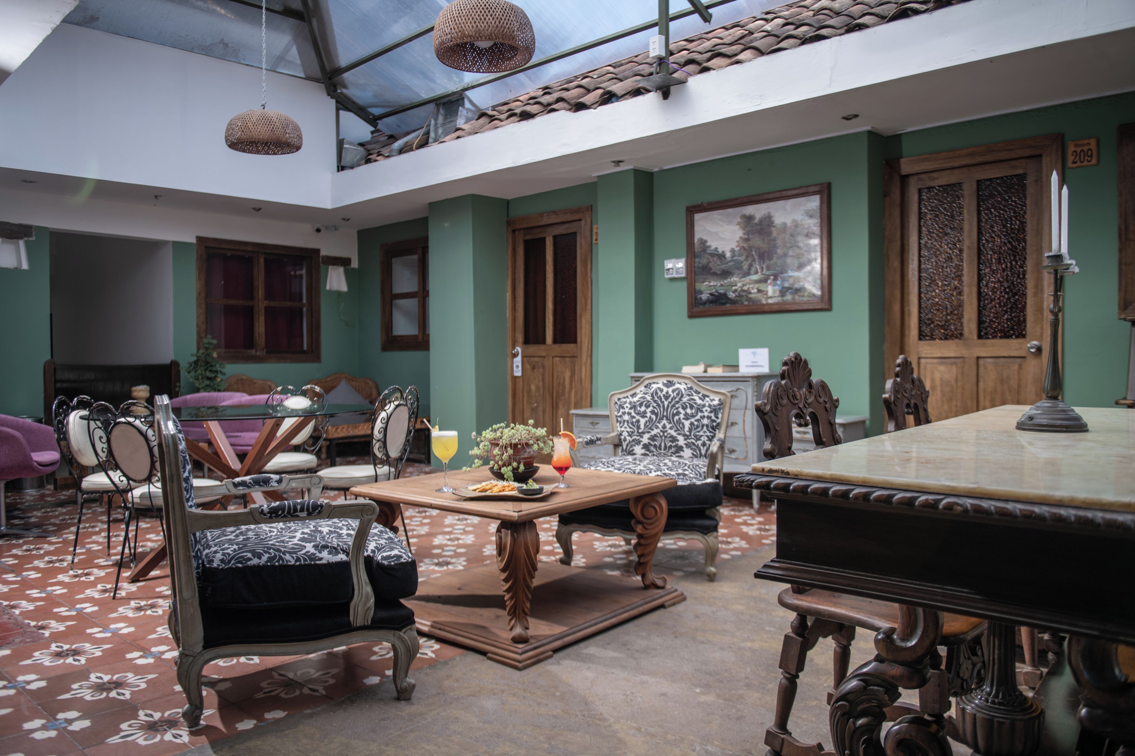 A spacious room with a high ceiling, a wooden dining table, and a variety of chairs.
