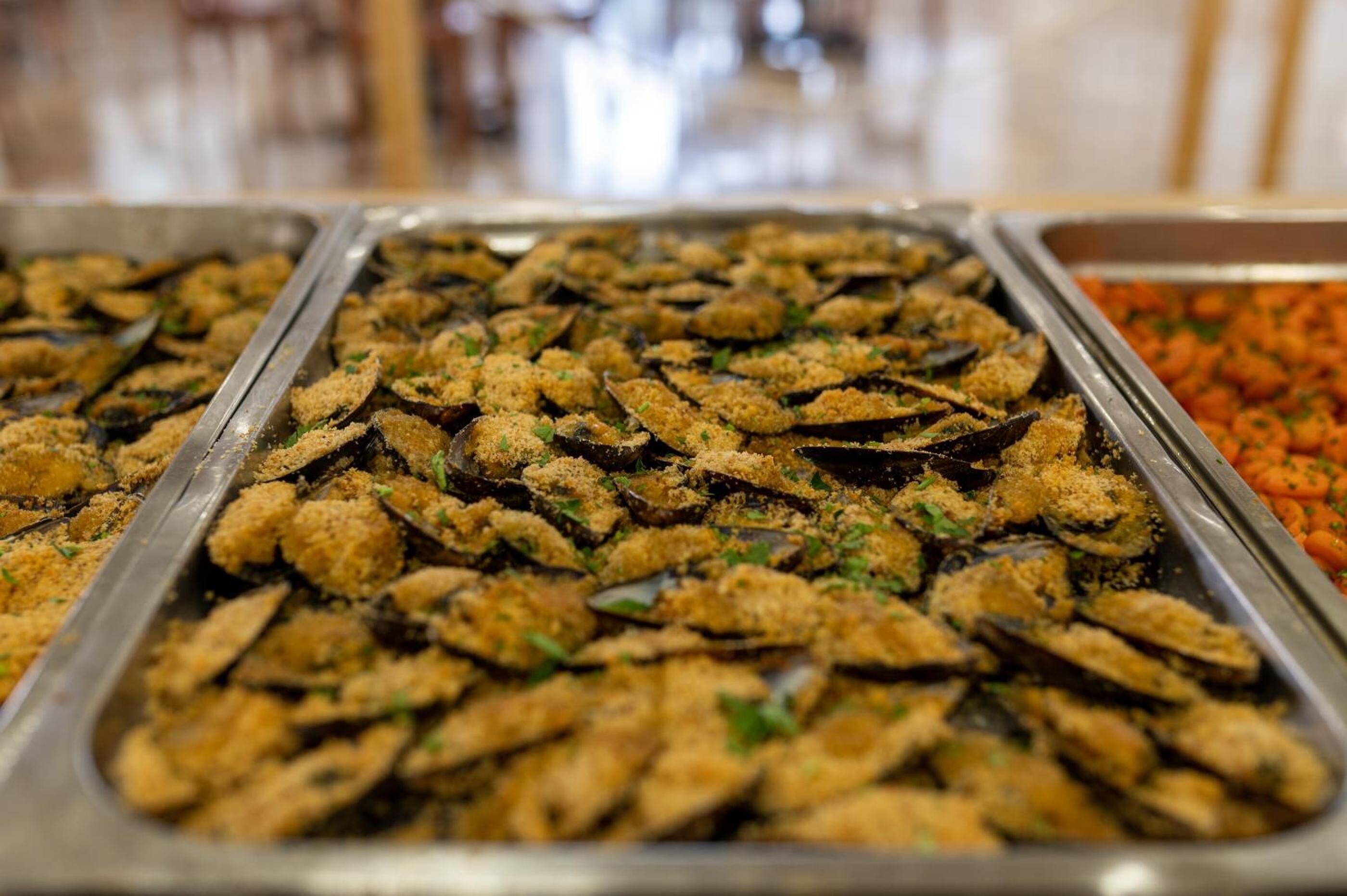 Un buffet con diversi piatti, tra cui pesce impanato e fritto.