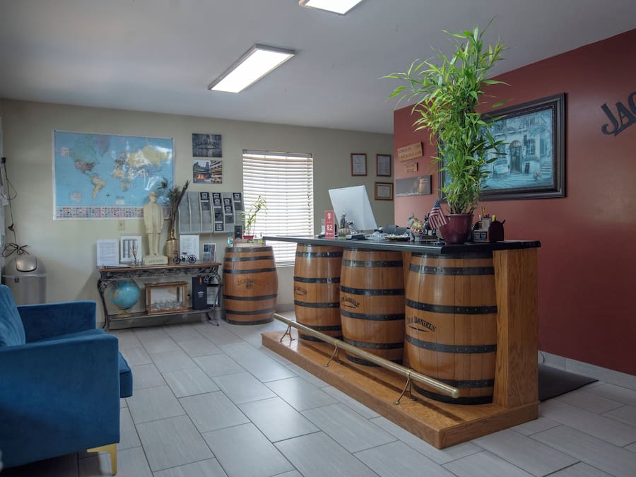 A reception area with a wooden bar, blue sofa, and a world map on the wall.