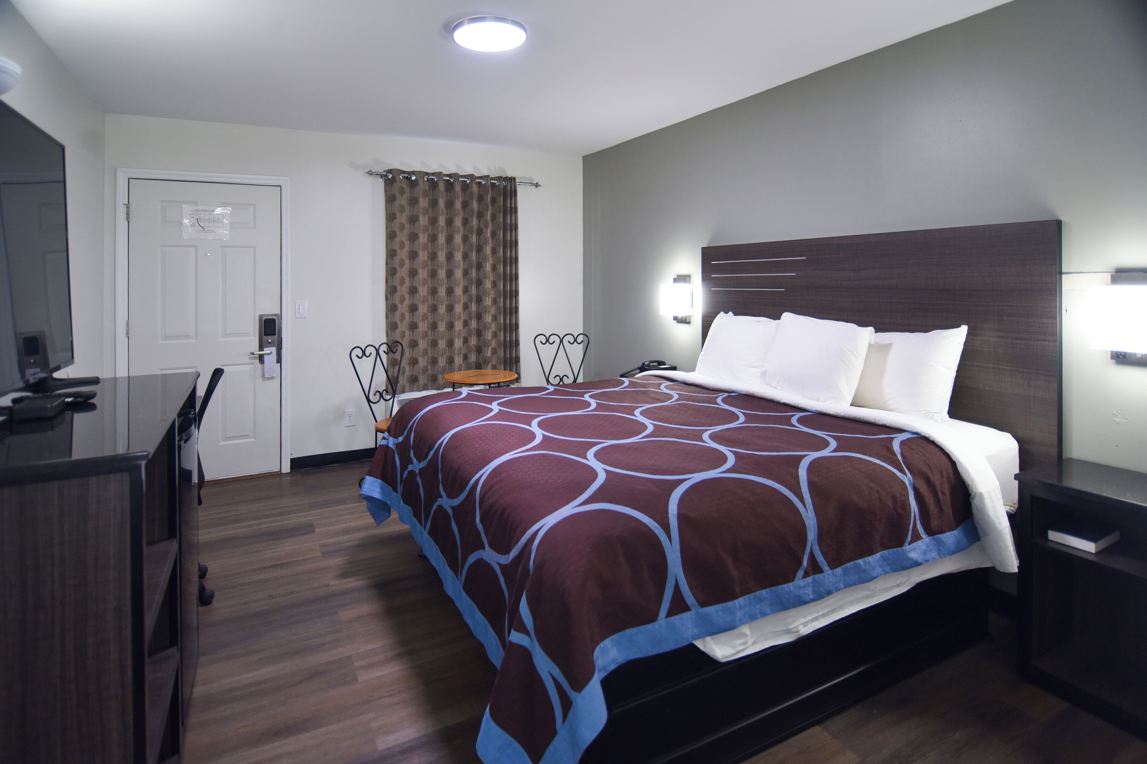 Una habitación de hotel con una cama grande, un escritorio y una silla.