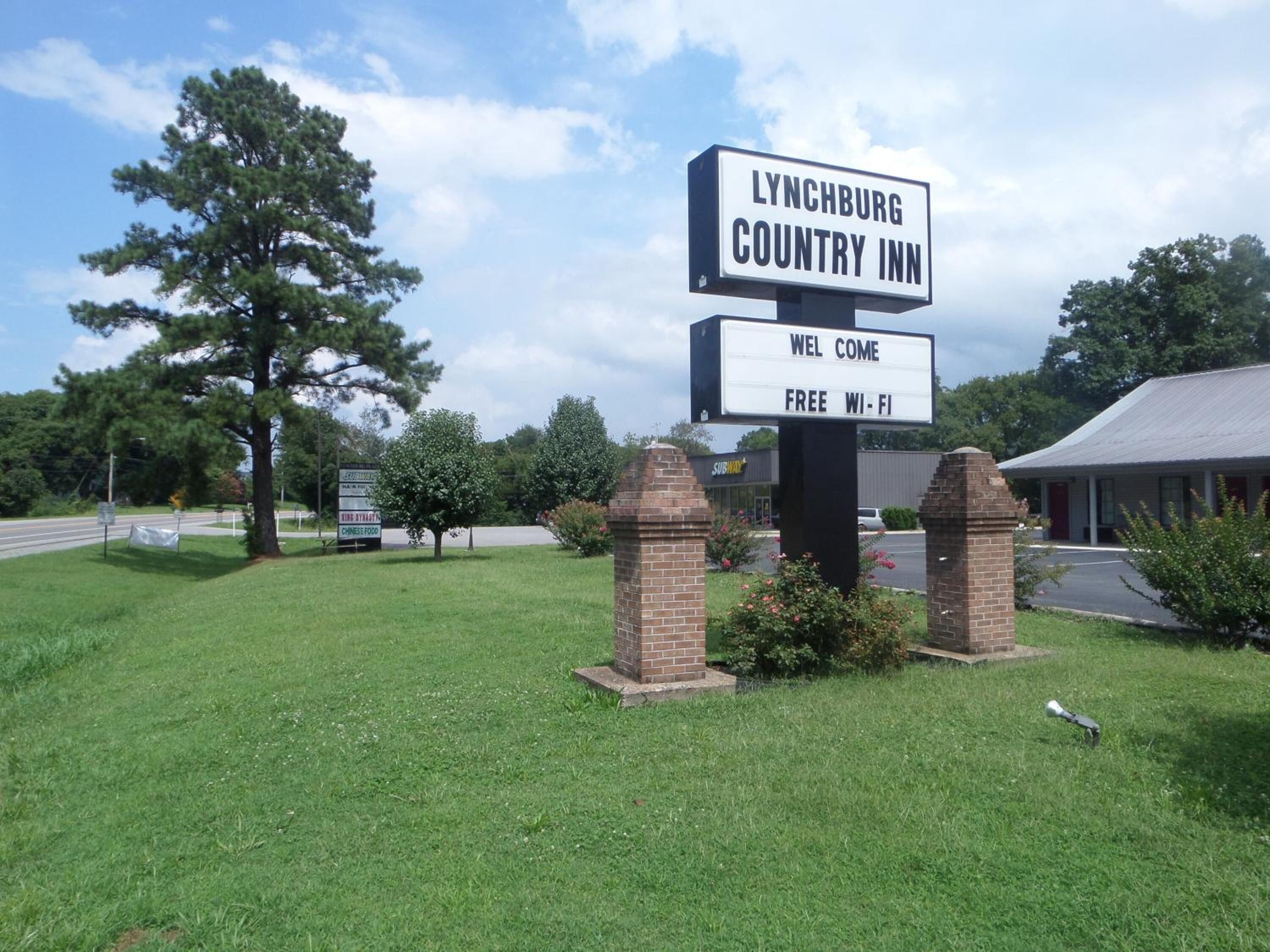 A sign for Lynchburg Country Inn with a welcome message and free Wi-Fi availability.
