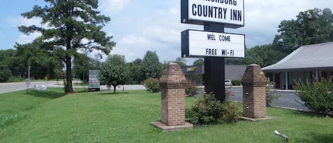 A sign for Lynchburg Country Inn with a welcome message and free Wi-Fi availability.