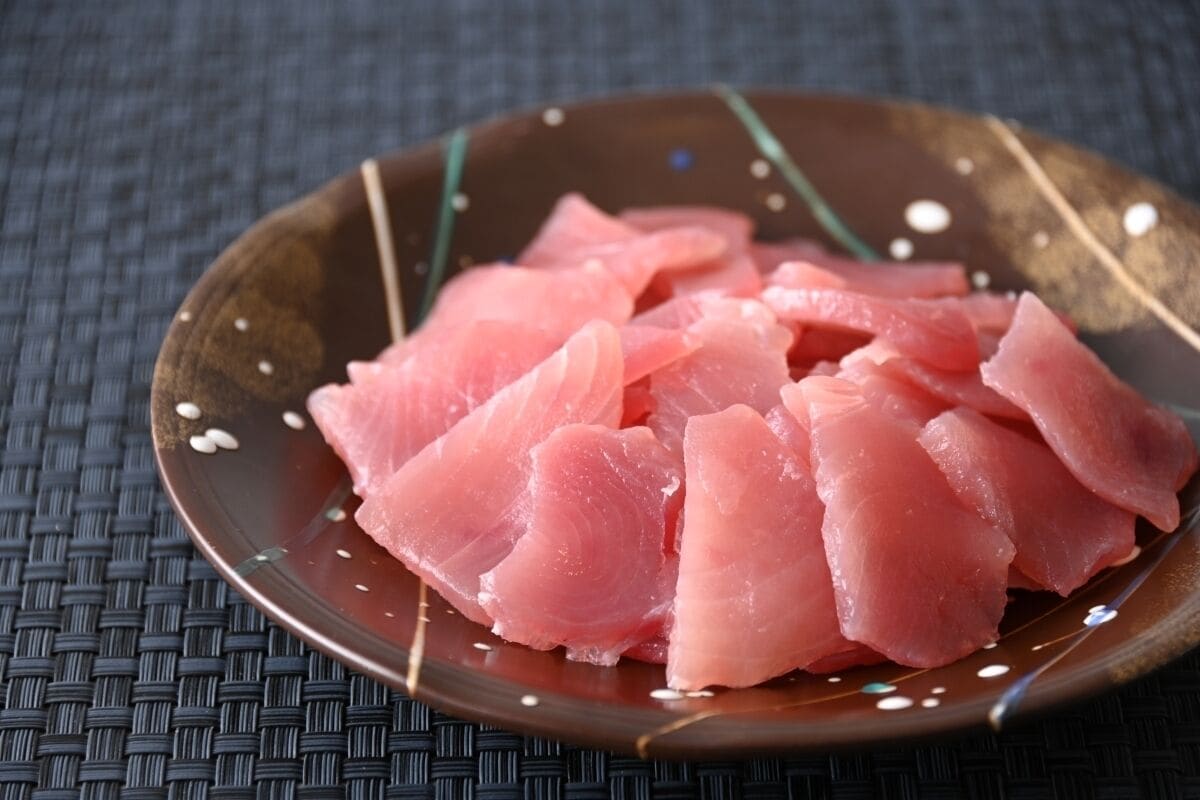 A plate of raw fish on a textured surface.