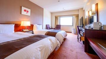 A hotel room with two beds, a desk with a chair, a television, and a window with curtains.
