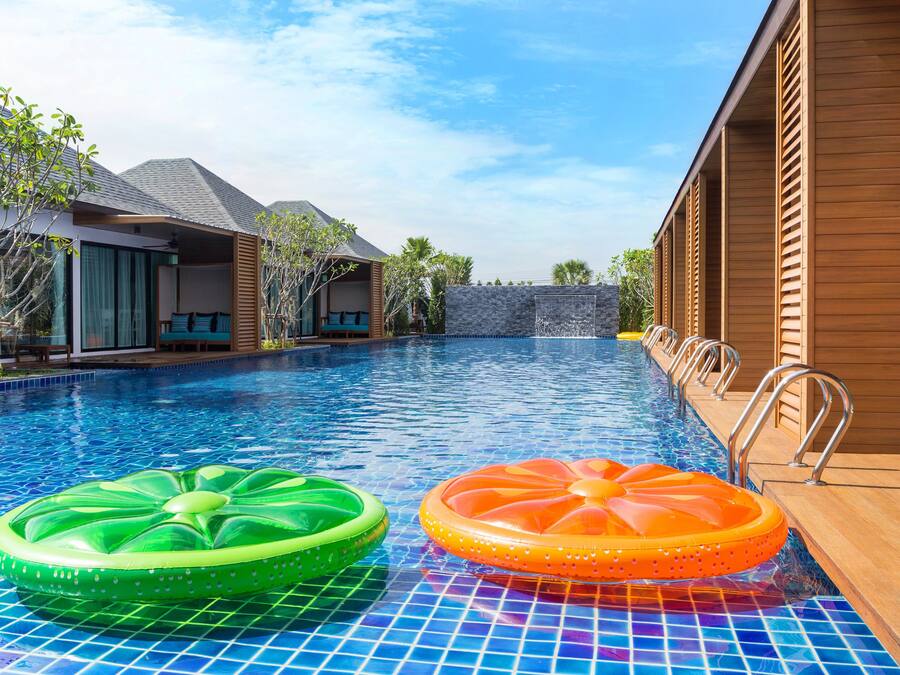 Una piscina al aire libre, sillones reclinables de piscina