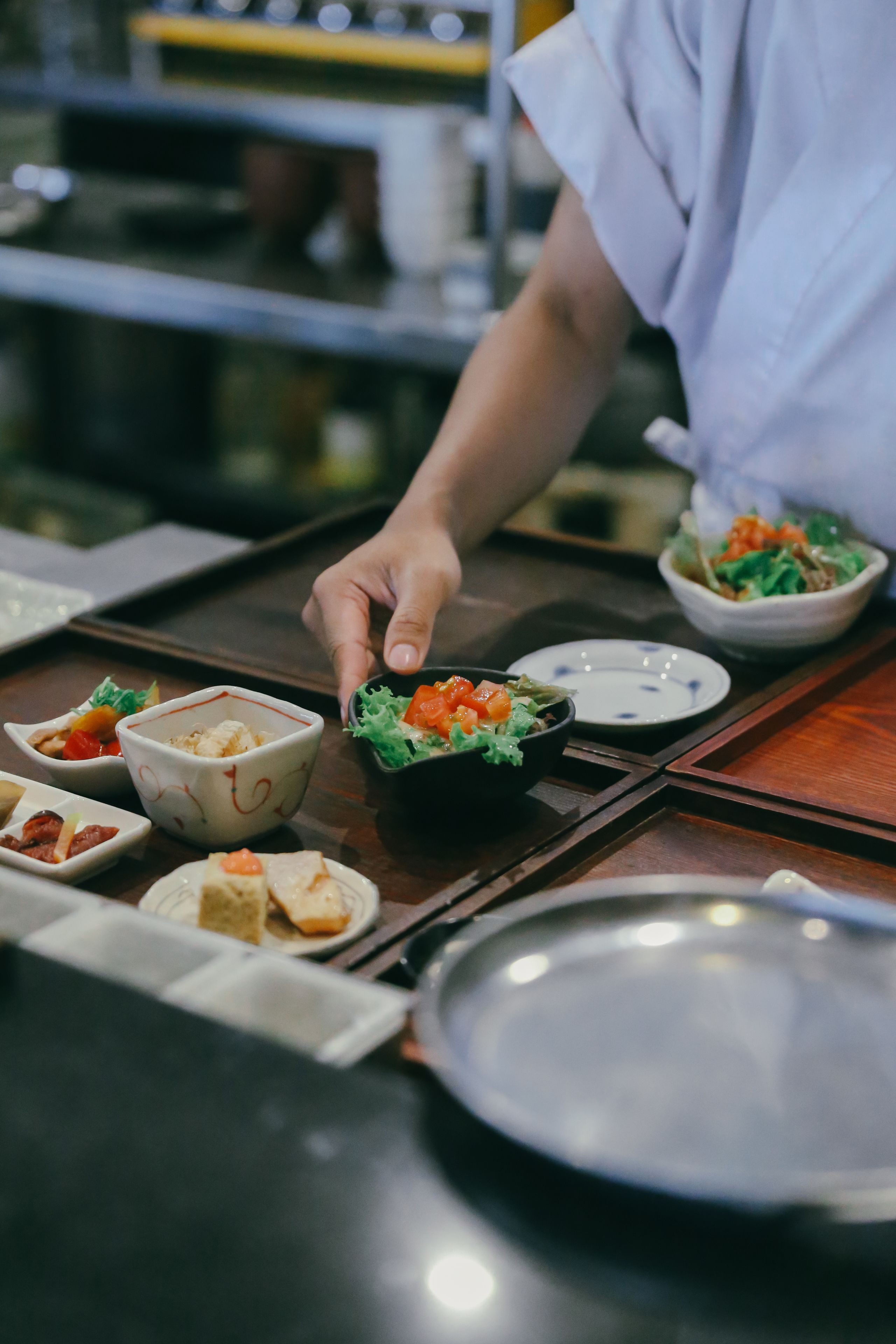 Une table à manger avec différents plats, notamment un saladier rempli de salade et une assiette de nourriture.