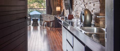 A modern kitchen with a wooden floor, built-in appliances, and a view of the outdoors.