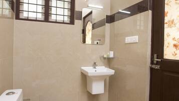 A bathroom with a toilet, sink, mirror, and a window with bars.