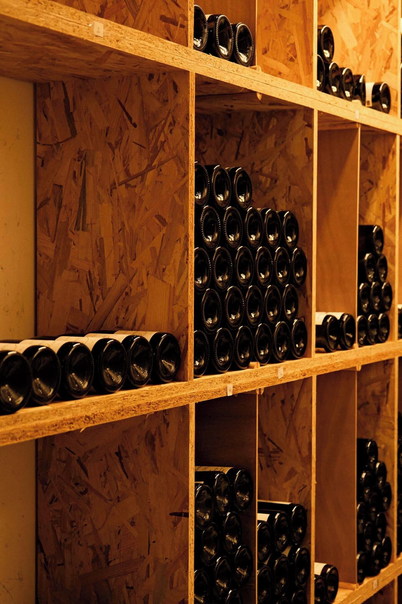 A storage area with shelves containing multiple wine bottles.
