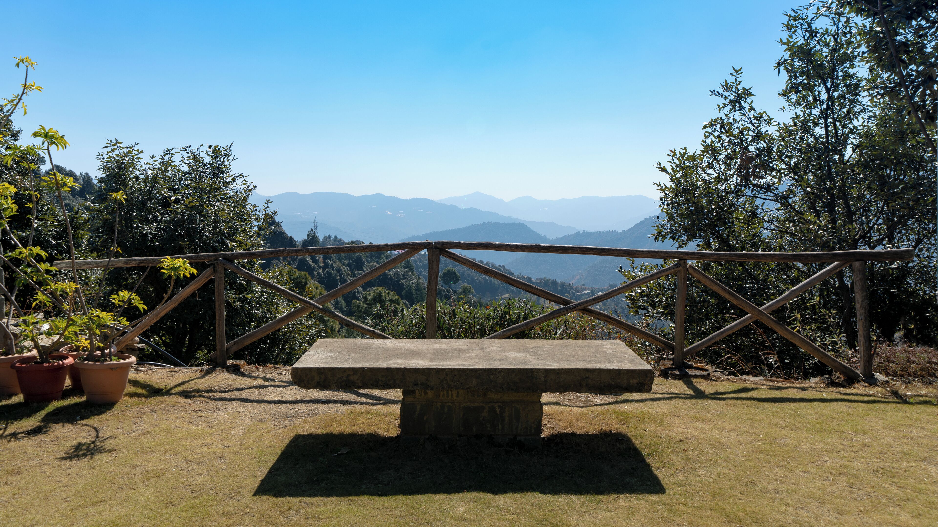 A stone bench with a view of distant mountains.