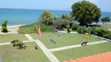 Relax and unwind with a clear view of the sea, featuring swings, a slide, and a bench for adults to sit and enjoy the surroundings.
