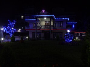 Vista frontal de la propiedad por la tarde o noche