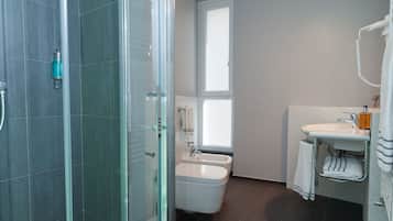 Een moderne badkamer met een douchecabine, een badkuip en een wastafel met een handdoekhouder.