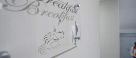 A wall-mounted sign with the words "Breakfast" and a coffee cup illustration.