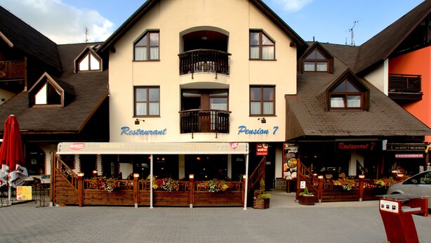 A building with a restaurant named "Pension 7" on the ground floor.