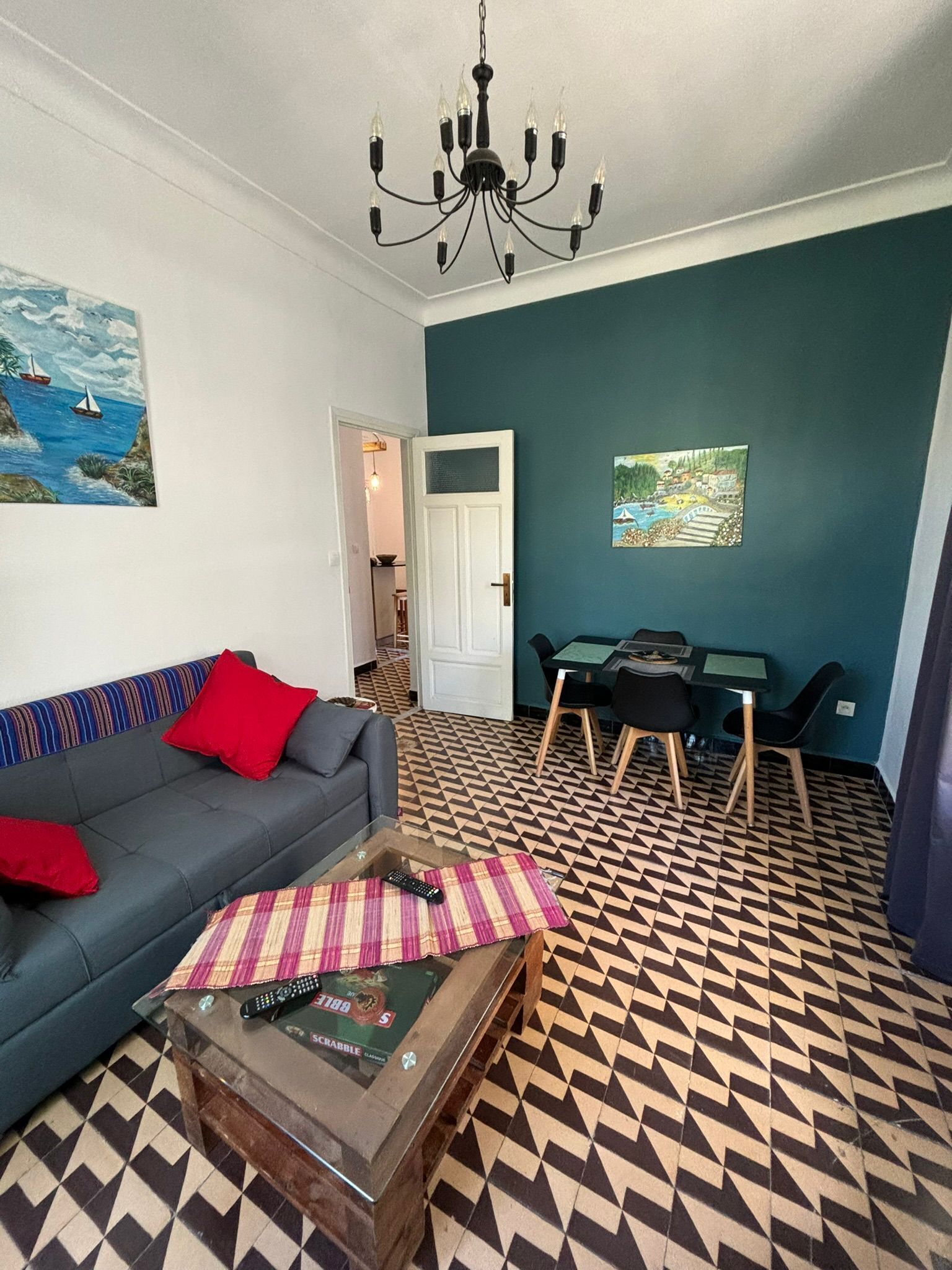 A living room with a sofa, coffee table, and a dining area with chairs and a table.