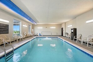 Una piscina con sillas y un puesto de salvavidas.