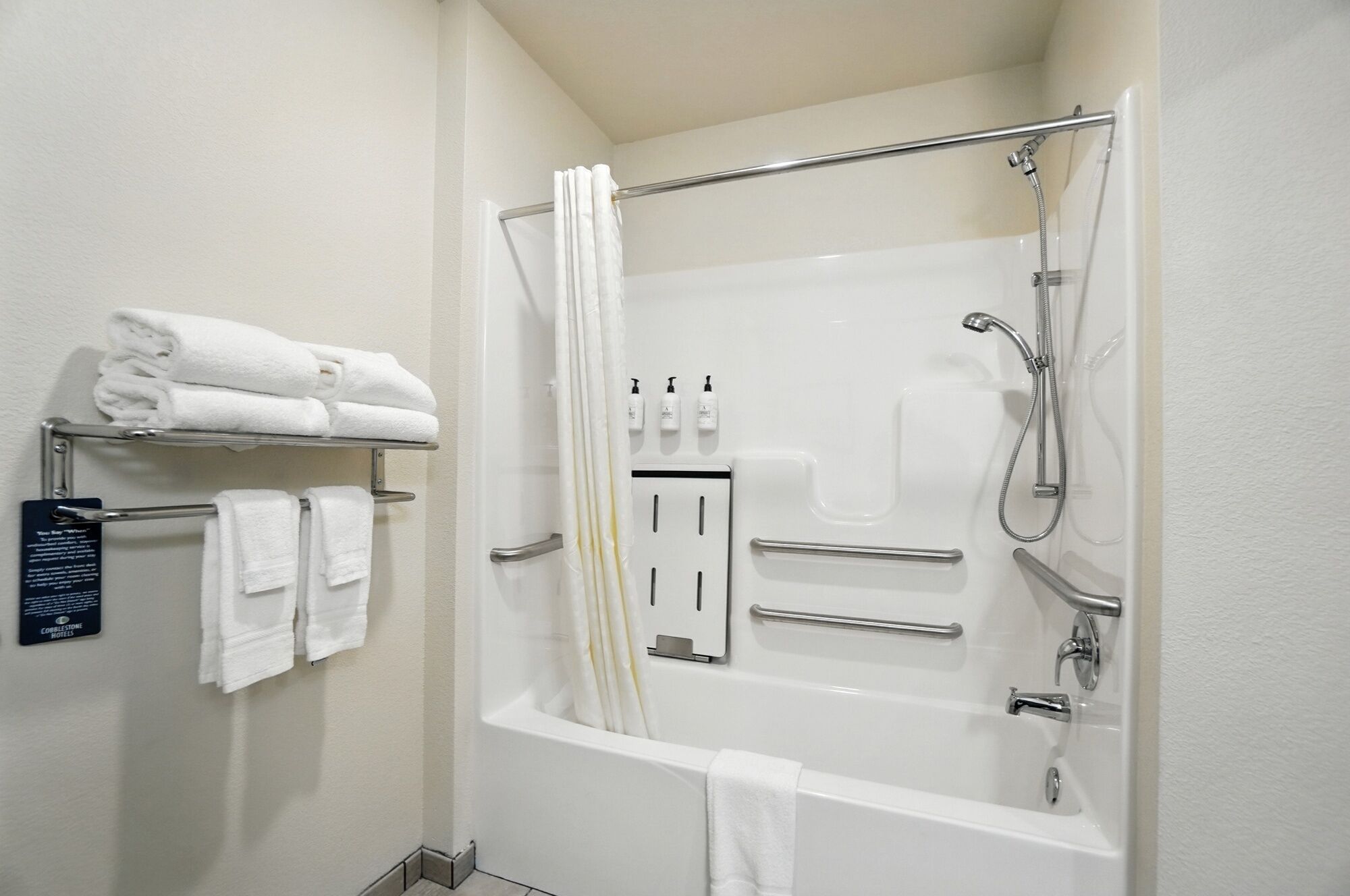 A modern bathroom with a bathtub, shower, and towel rack.