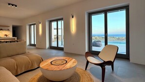 Una sala de estar moderna con un ventanal grande, una mesa redonda y un sofá.