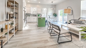 A modern kitchen with white cabinetry, a dining area with a bench and chairs, and a ceiling fan. - Stylish OKC Duplex 2bed 2.5bath Unit B (Oklahoma City)