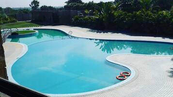 Relax by the serene pool surrounded by lush greenery.