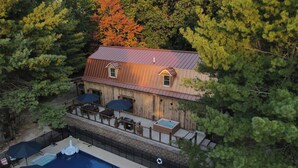 Une cabane en bois avec une piscine, entourée d’arbres.