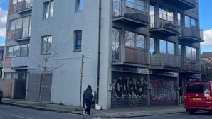 A multi-story building with balconies, large windows, and a garage door with graffiti. - Modern spacious apartment, direct access to London Bridge and central London (London)