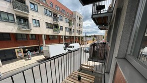 A balcony with a wooden bench, a railing, and a view of a street with buildings and a white van. - Modern spacious apartment, direct access to London Bridge and central London (London)