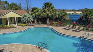 A swimming pool with a curved edge, surrounded by lounge chairs and a small building. - Spacious 4-bedroom townhome with Cable and WiFi in charming Sanford (Sanford)