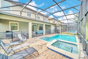 A covered outdoor swimming pool area with lounge chairs and a barbecue grill. - 1422Moon 6BR / 6BA Champions Gate Villa near to Disney, Private Pool & GamesRoom (Davenport)