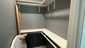 A small, enclosed room with a wooden floor, grey walls, and white shelving units. - Charming 1-bedroom cottage in Ridge/Judice community with central AC/Heating.  (Lafayette)