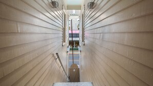 A narrow hallway with wooden paneling and a central walkway. - Duval Dream Loft by Brightwild Right on Duval (Key West)