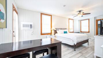 Un dormitorio con cama, mesita de noche, lámpara y ventilador de techo.
